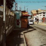 A vibrant urban street in Mérida, Venezuela, showcasing daily life under bright sunlight.