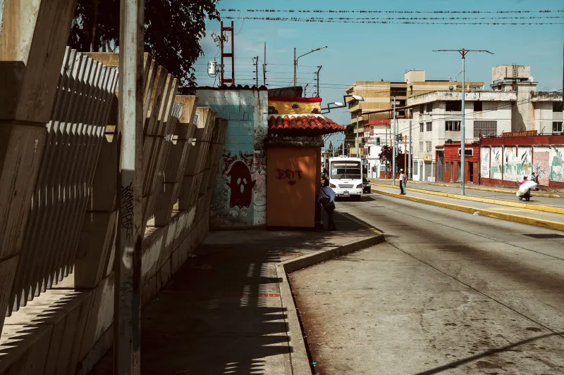 A vibrant urban street in Mérida, Venezuela, showcasing daily life under bright sunlight.