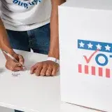 Close-up of man voting at ballot box, emphasizing democratic participation.