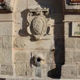 Old stone fountain in Jerez de la Frontera with non-potable water sign.