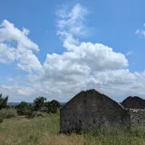 Enjoy the tranquil scene of a stone cottage ruin against a clear blue sky in Salir do Porto, Portugal.