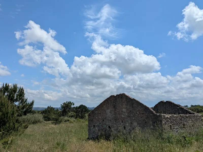 Enjoy the tranquil scene of a stone cottage ruin against a clear blue sky in Salir do Porto, Portugal.