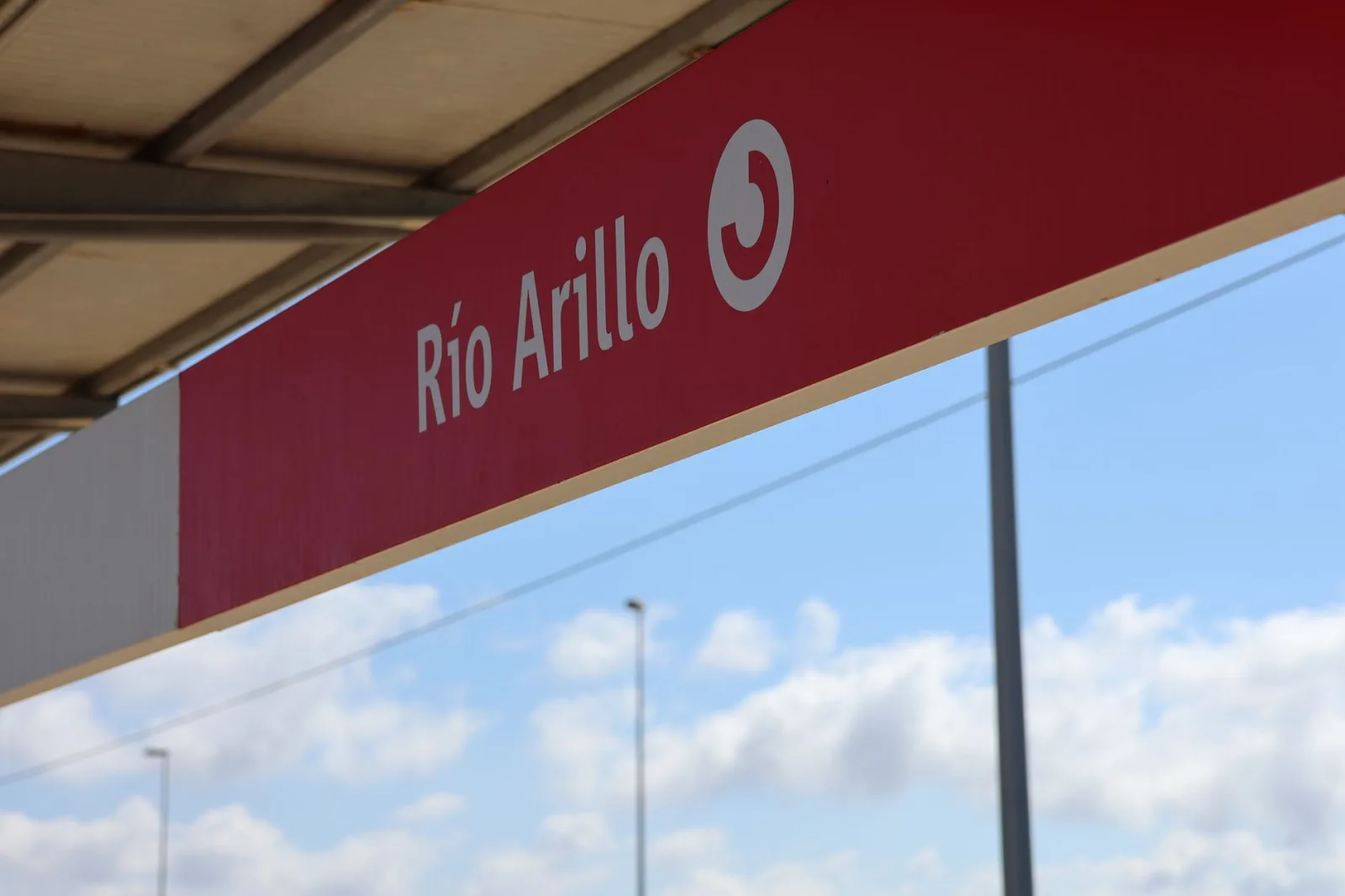 Detailed view of the Río Arillo station sign in San Fernando under a clear sky.