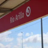 Detailed view of the Río Arillo station sign in San Fernando under a clear sky.
