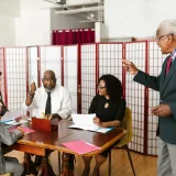 Grupo de colegas conversando durante una reunión de negocios en una oficina.