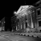 Dramatic black and white image of the Congreso de los Diputados in Madrid at night.
