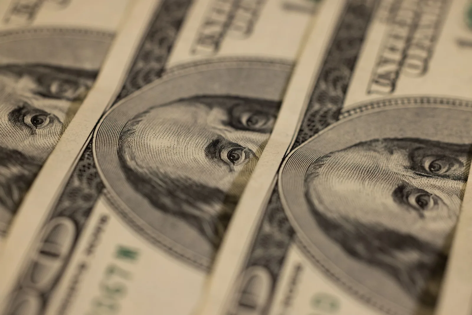 Primer plano detallado de varios billetes de dólar estadounidense que muestran el intrincado diseño de la moneda.