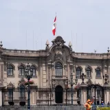 Vista del histórico Palacio de Gobierno en Lima, Perú, con un trabajador en primer plano.