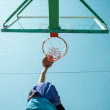 Plano dinámico desde un ángulo bajo de un jugador de baloncesto haciendo una clavada al aire libre en Bagdad, Irak.