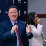 Un hombre y una mujer de pie frente a un micrófono.