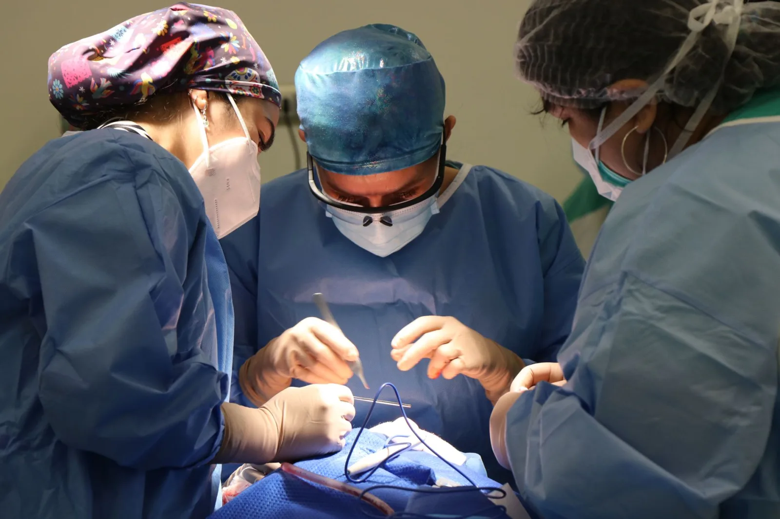Equipo médico concentrado en una cirugía, demostrando atención médica y precisión.