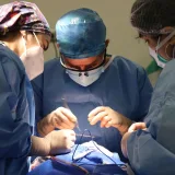 Equipo médico concentrado en una cirugía, demostrando atención médica y precisión.