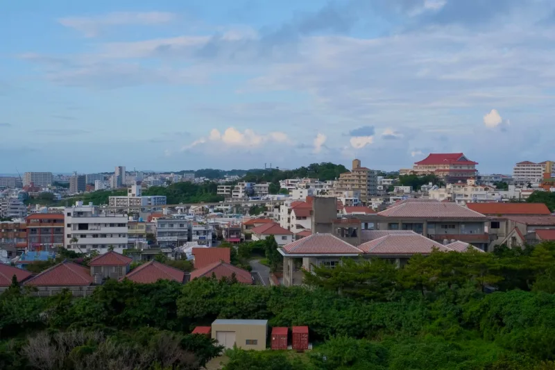 Panoramic view of Okinawa cityscape with traditional and modern buildings.