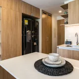 Stylish kitchen interior featuring wooden cabinetry and elegant tableware on a counter in Chía, Colombia.