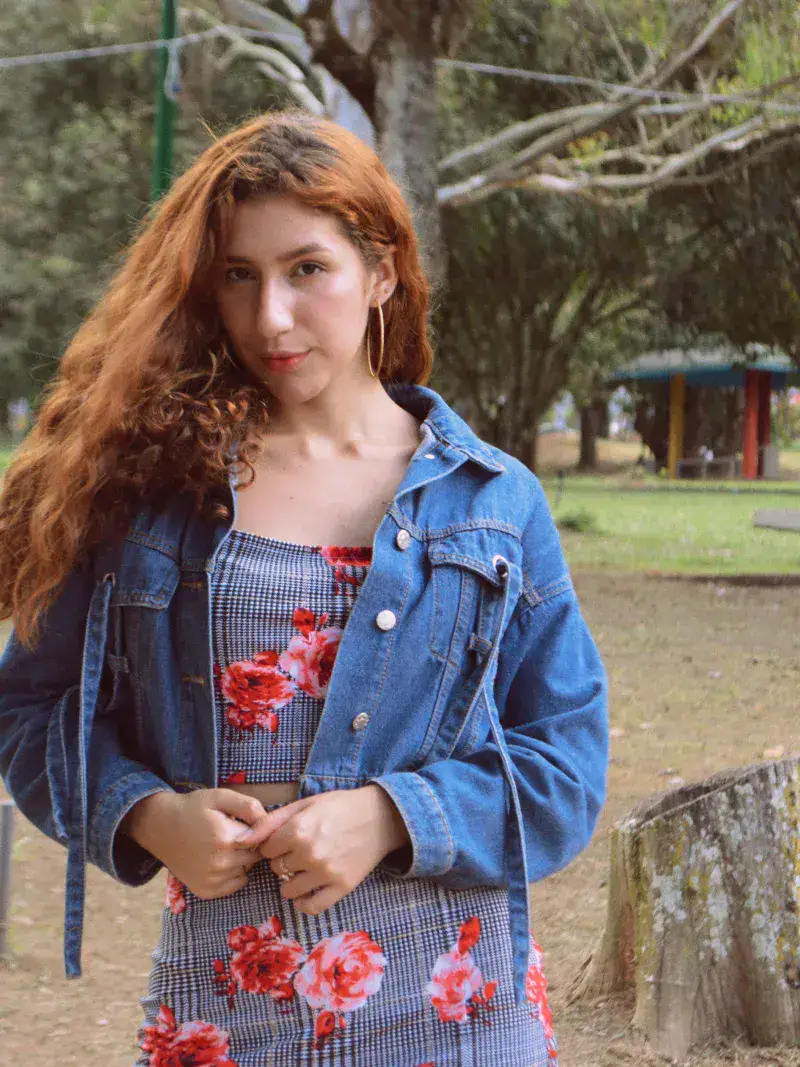 Young woman with red hair posing in a denim jacket outdoors in Táchira, Venezuela.