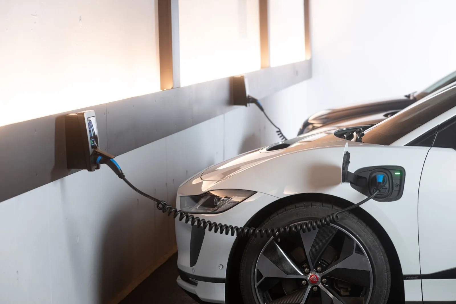 Carga de un automóvil eléctrico en una estación interior moderna que promueve la sostenibilidad y la eficiencia energética.