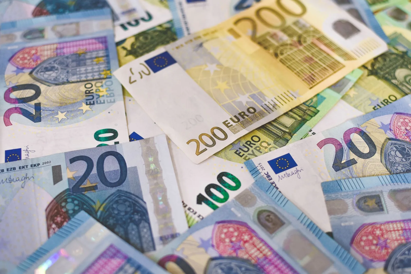 Primer plano de varios billetes de euro esparcidos sobre una superficie, que destacan la moneda europea.