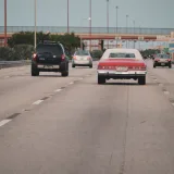 Escena de tráfico en una autopista de Miami, Florida, con un automóvil clásico que evoca el ambiente de los viajes urbanos.
