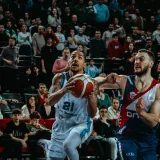 Toma de acción dinámica de un partido de baloncesto en vivo que captura la competencia y la participación del público.