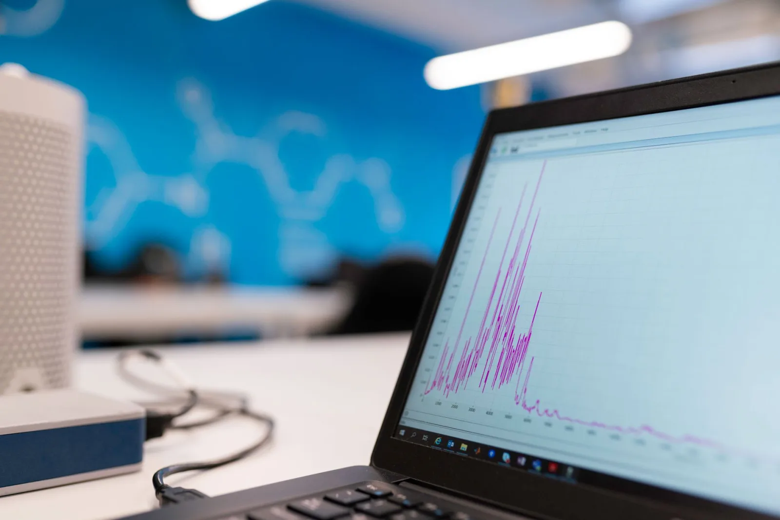 Portátil mostrando un gráfico de análisis de datos en una oficina moderna, símbolo de crecimiento y tecnología.