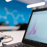 Portátil mostrando un gráfico de análisis de datos en una oficina moderna, símbolo de crecimiento y tecnología.