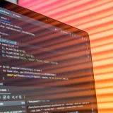 Reflejo abstracto y colorido en una pantalla que muestra código de programación en un entorno de desarrollo.