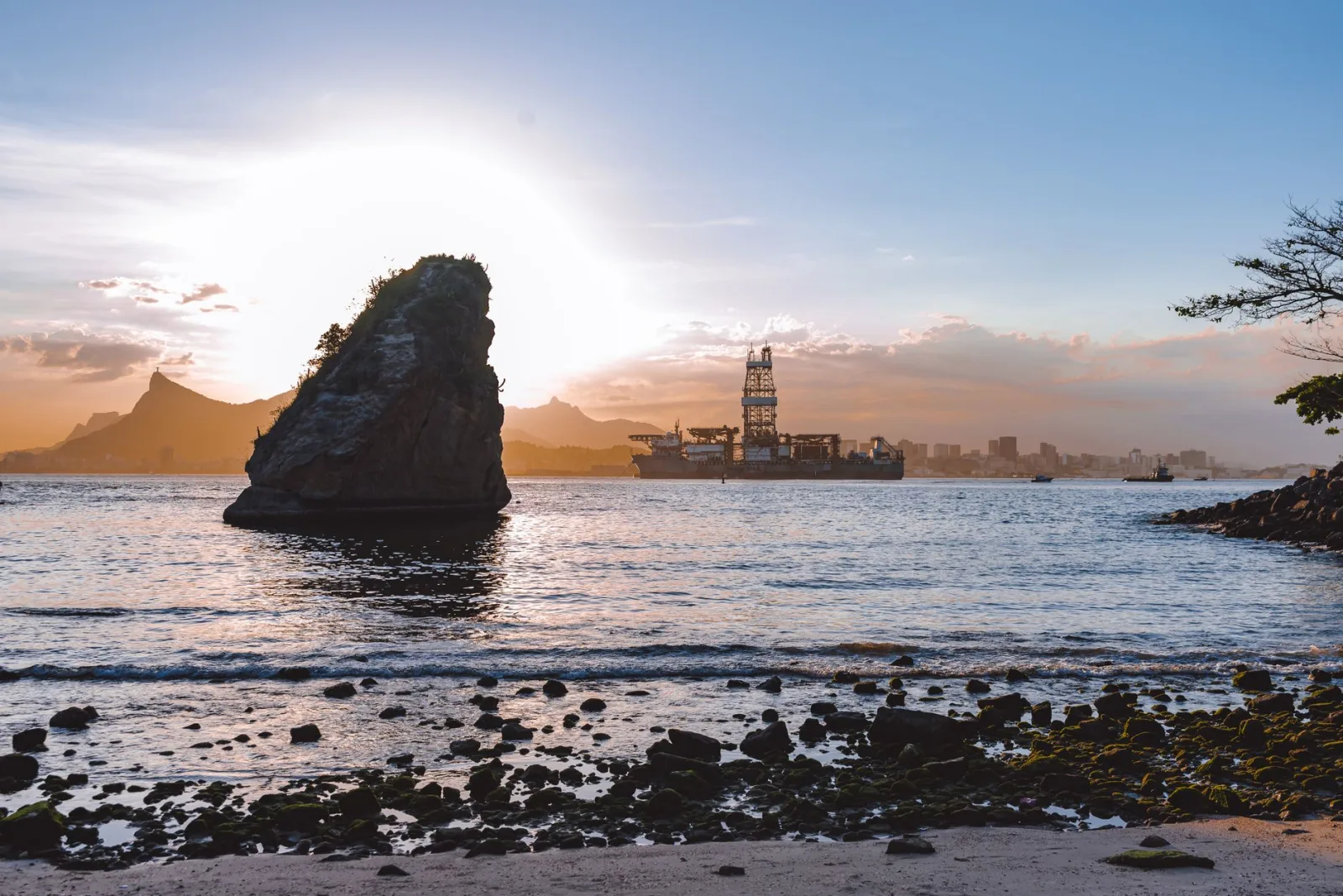 Stunning view of Rio de Janeiro's coastal landscape with oil platform at sunset.