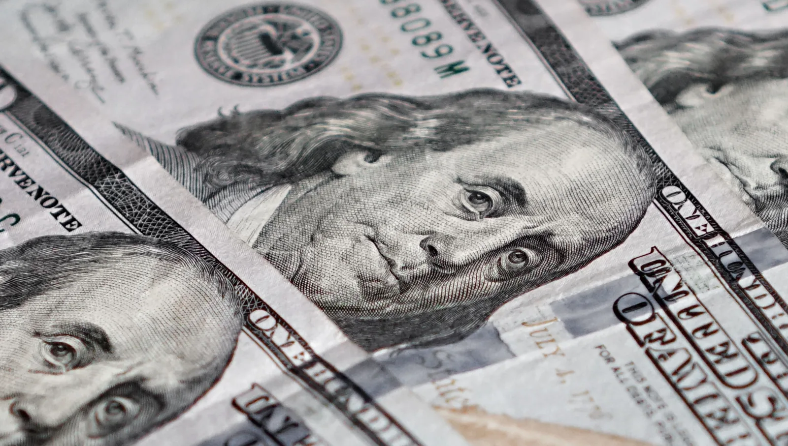 Imagen detallada de billetes de cien dólares estadounidenses con Benjamin Franklin.