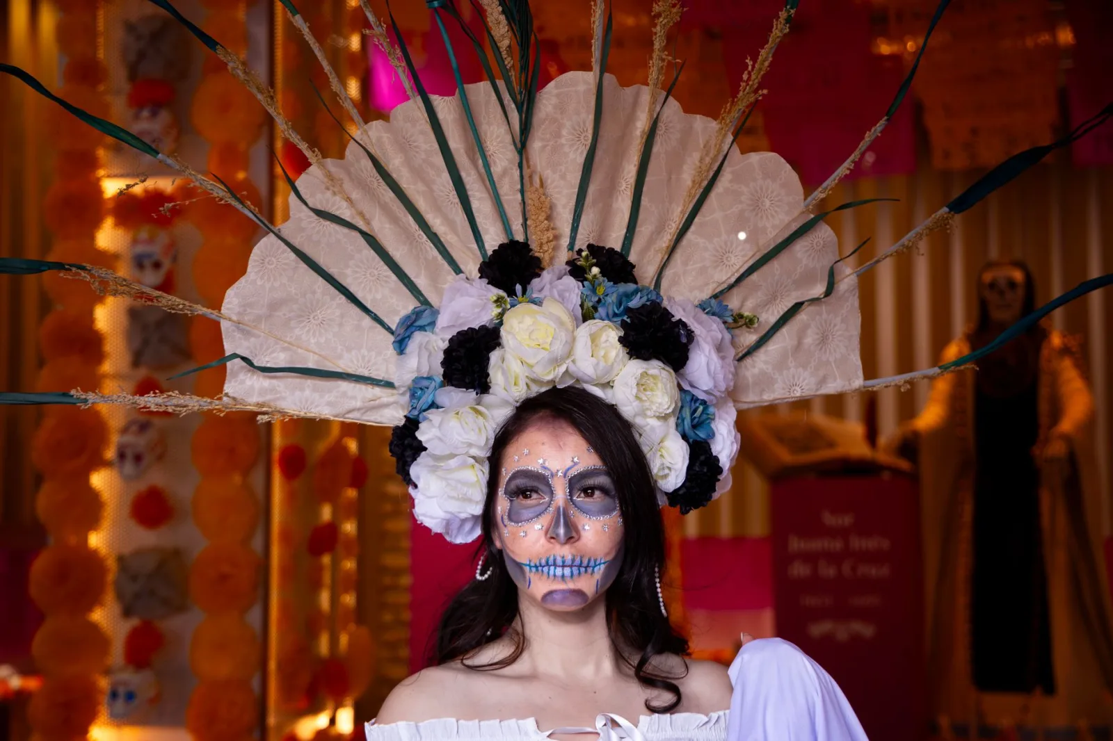 Portrait of a woman in colorful Catrina makeup and costume celebrating Dia de los Muertos in Toluca, Mexico.