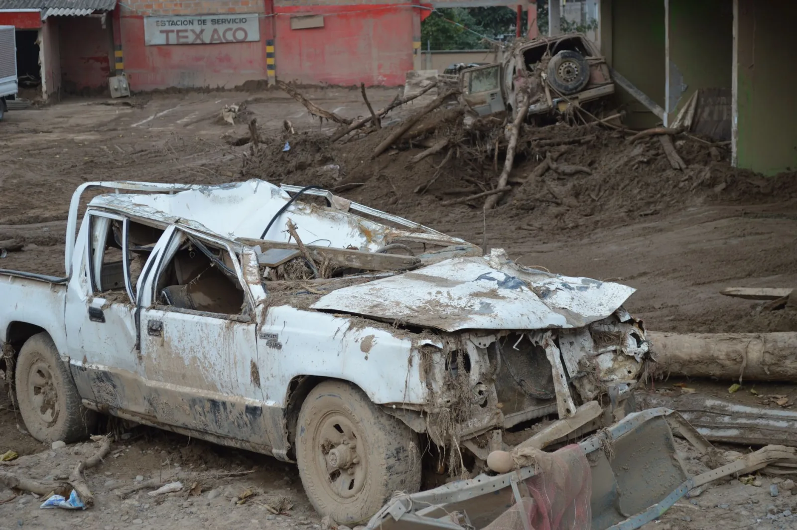 Vehículo aplastado entre los escombros tras un grave deslizamiento de tierra en Mocoa, Colombia, que evidencia la destrucción.