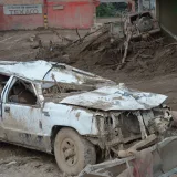 Vehículo aplastado entre los escombros tras un deslizamiento de lodo grave en Mocoa, Colombia, que pone de relieve la destrucción.