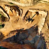 Stunning aerial photo showcasing a large open pit mining operation under sunny conditions.