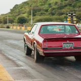 A classic car races on a scenic track in Turagua, Aragua, Venezuela, showcasing speed and adventure.