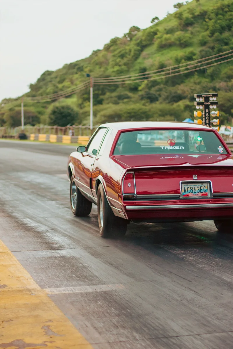 A classic car races on a scenic track in Turagua, Aragua, Venezuela, showcasing speed and adventure.