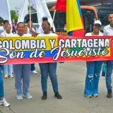 Group of people holding a 'Colombia y Cartagena' banner in a street parade.