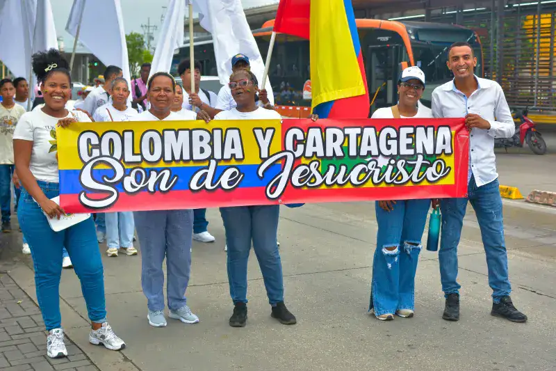 Group of people holding a 'Colombia y Cartagena' banner in a street parade.