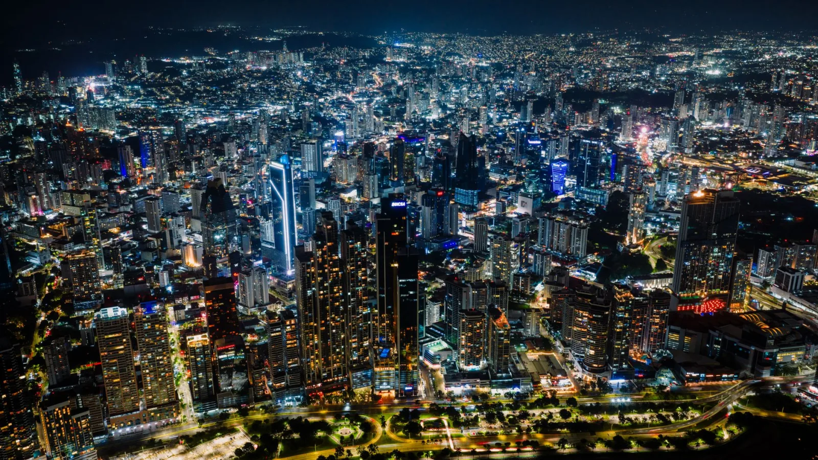 Impresionante vista aérea del vibrante horizonte de Ciudad de Panamá por la noche, un paisaje urbano lleno de actividad.