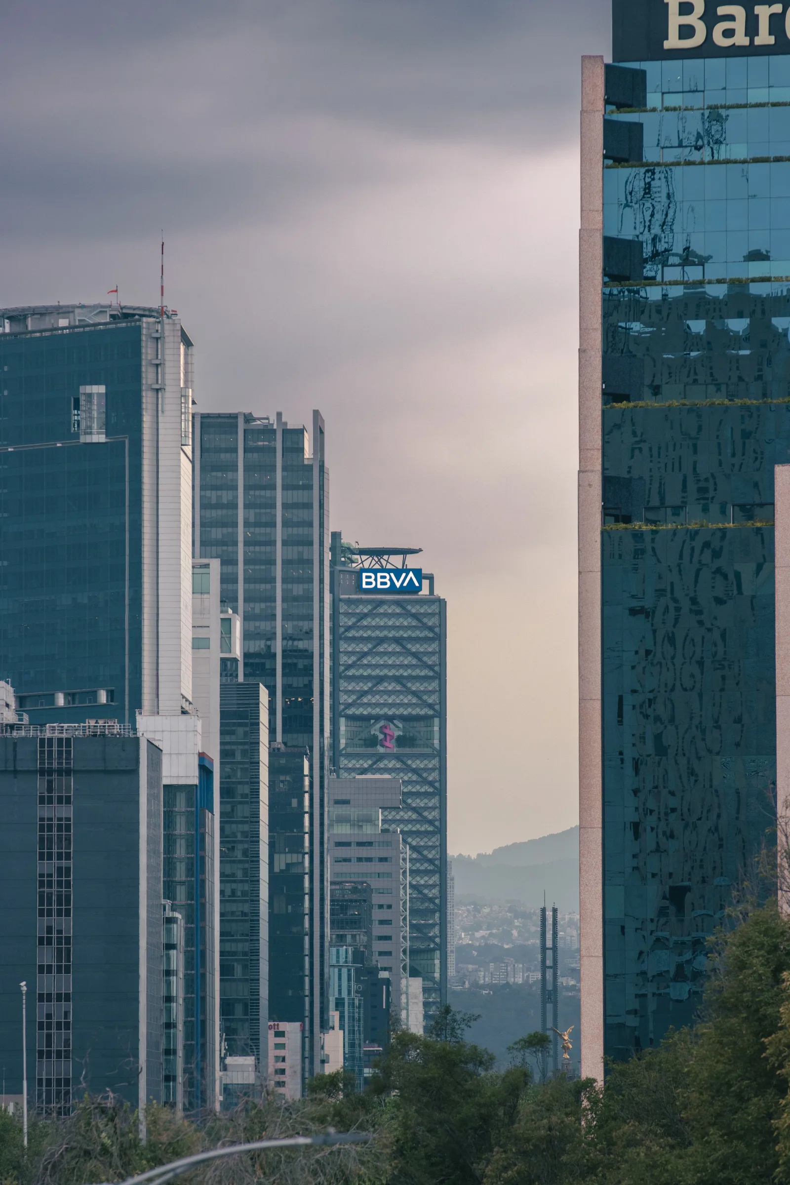 Vista urbana de los rascacielos de la Ciudad de México resaltando el edificio BBVA bajo un cielo nublado.