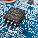 Imagen macro detallada de un microchip montado en una placa de circuito azul.