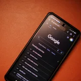 A smartphone displaying Google Search trends on a table at night.