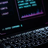 Primer plano de un teclado de portátil brillante con interfaz digital, que representa tecnología futurista