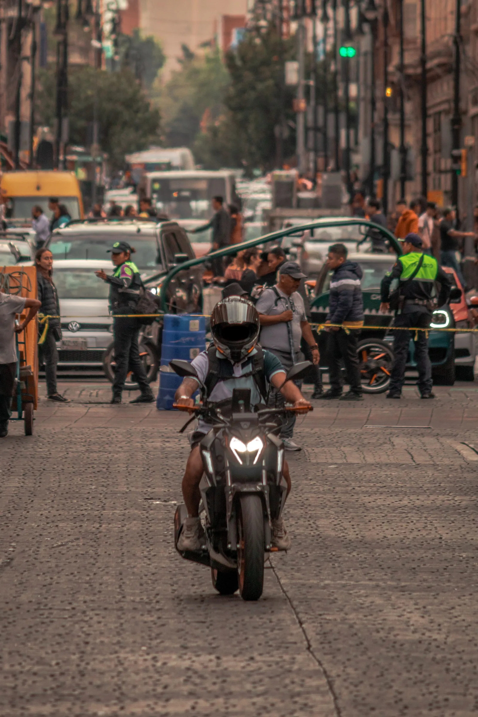 Motorcyclist navigating busy urban traffic in Ciudad de México, showcasing vibrant street life.