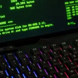 Primer plano de una pantalla de computadora retro que muestra comandos de MS-DOS junto a un teclado de colores vibrantes.