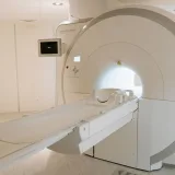 Un escáner de resonancia magnética de última generación en una sala hospitalaria bien iluminada, listo para atender a pacientes.