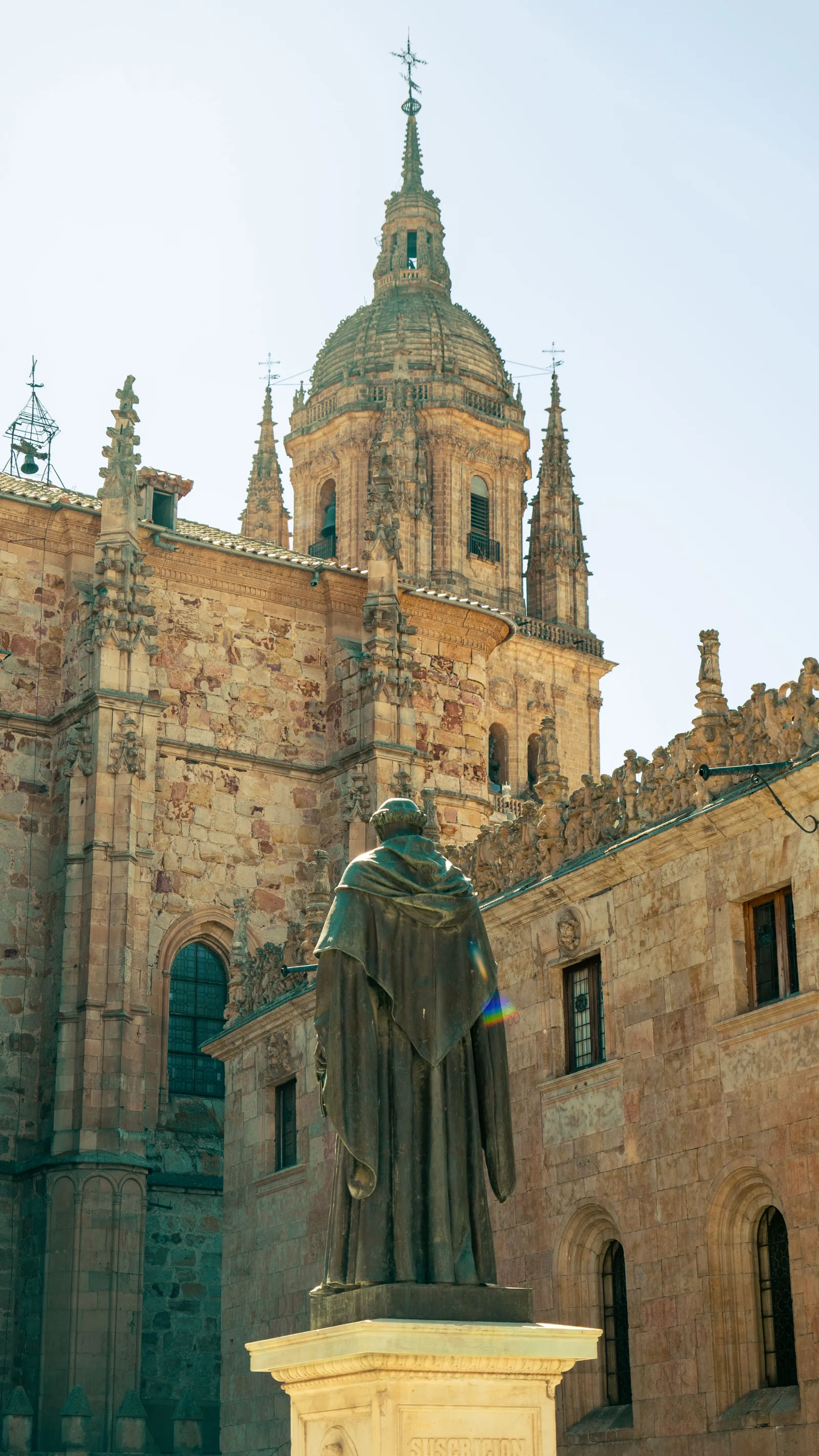 Statue of Fray Luis de León in front of Salamanca Cathedral's Gothic architecture.