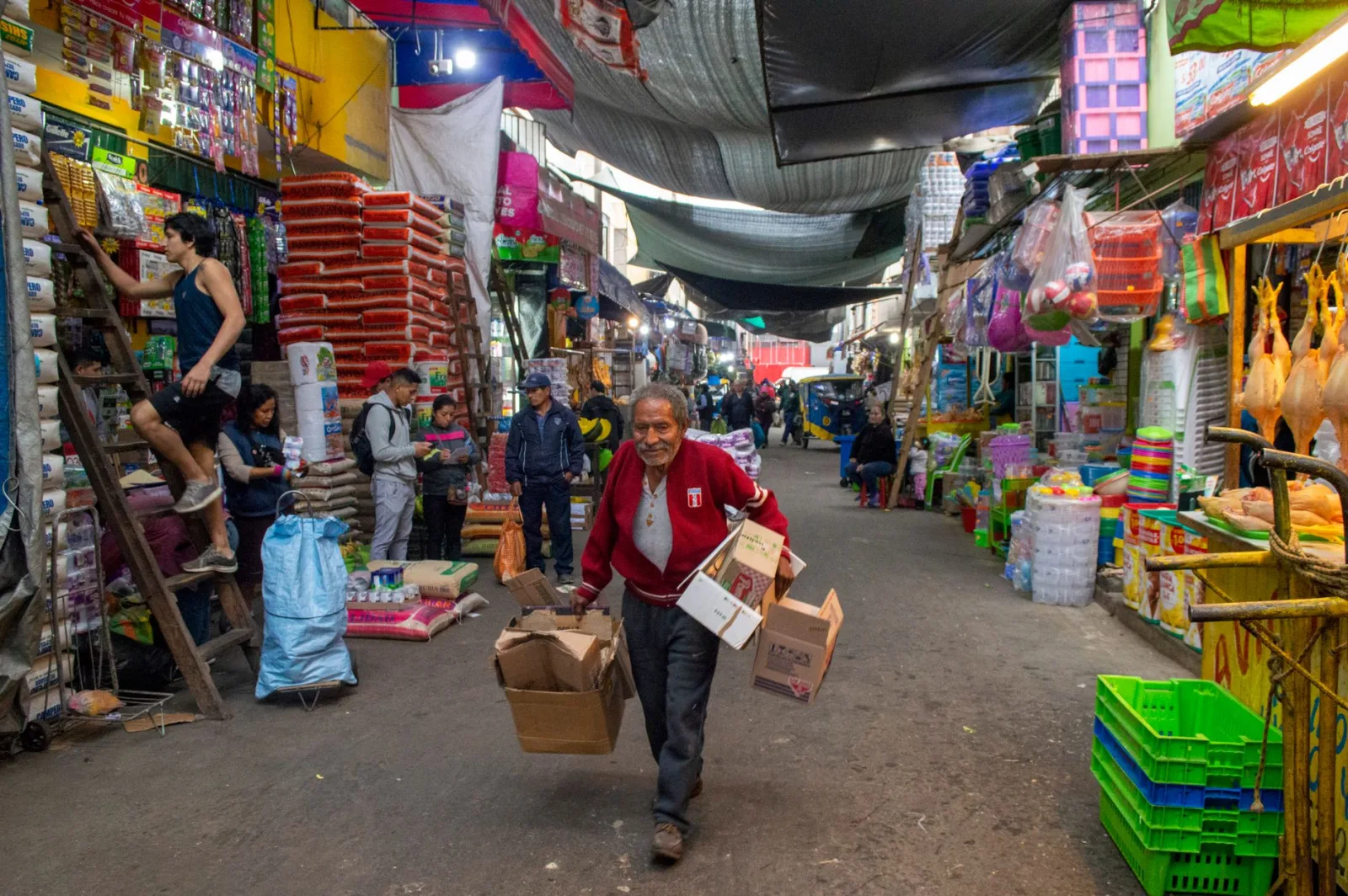 Animada escena de mercado callejero, con vendedores y clientes realizando transacciones comerciales.