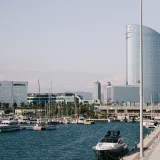 Modern architecture and boats in Barcelona's scenic harbor, with iconic skyline views.