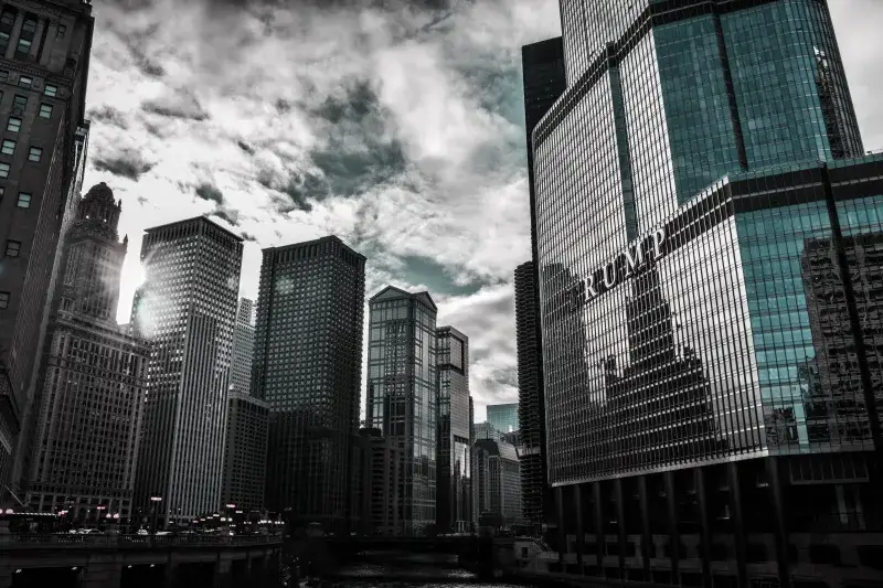 Chicago cityscape featuring Trump Tower with dramatic reflections against a cloudy sky.