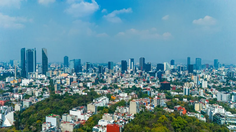 A panoramic view of Mexico City's skyline with skyscrapers and blue sky.