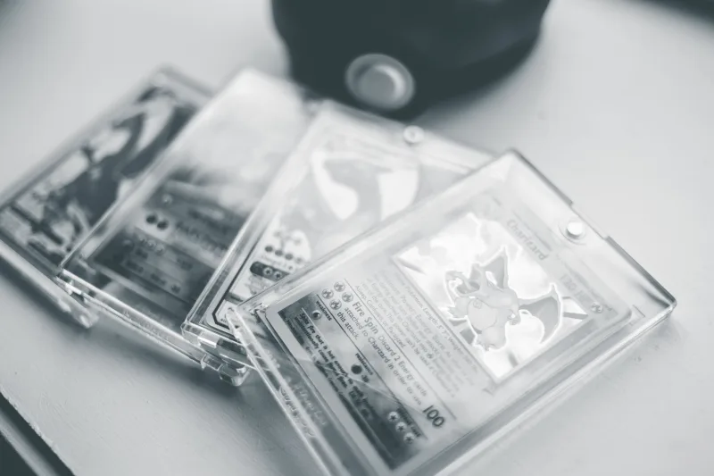 Primer plano de cartas coleccionables de Pokémon en estuches protectores, destacando su conservación y valor.